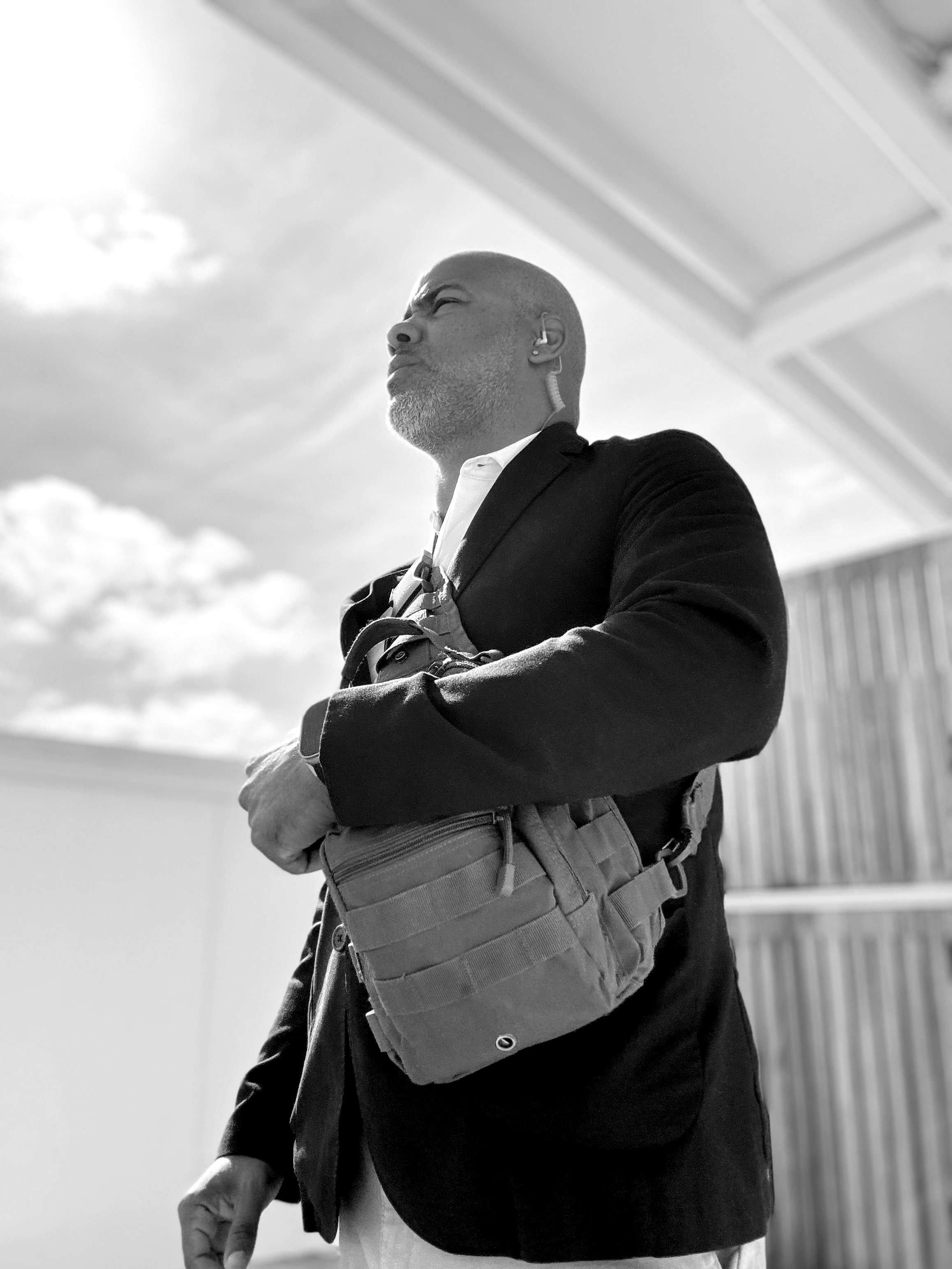 Felix standing post with arms crossed, commanding presence