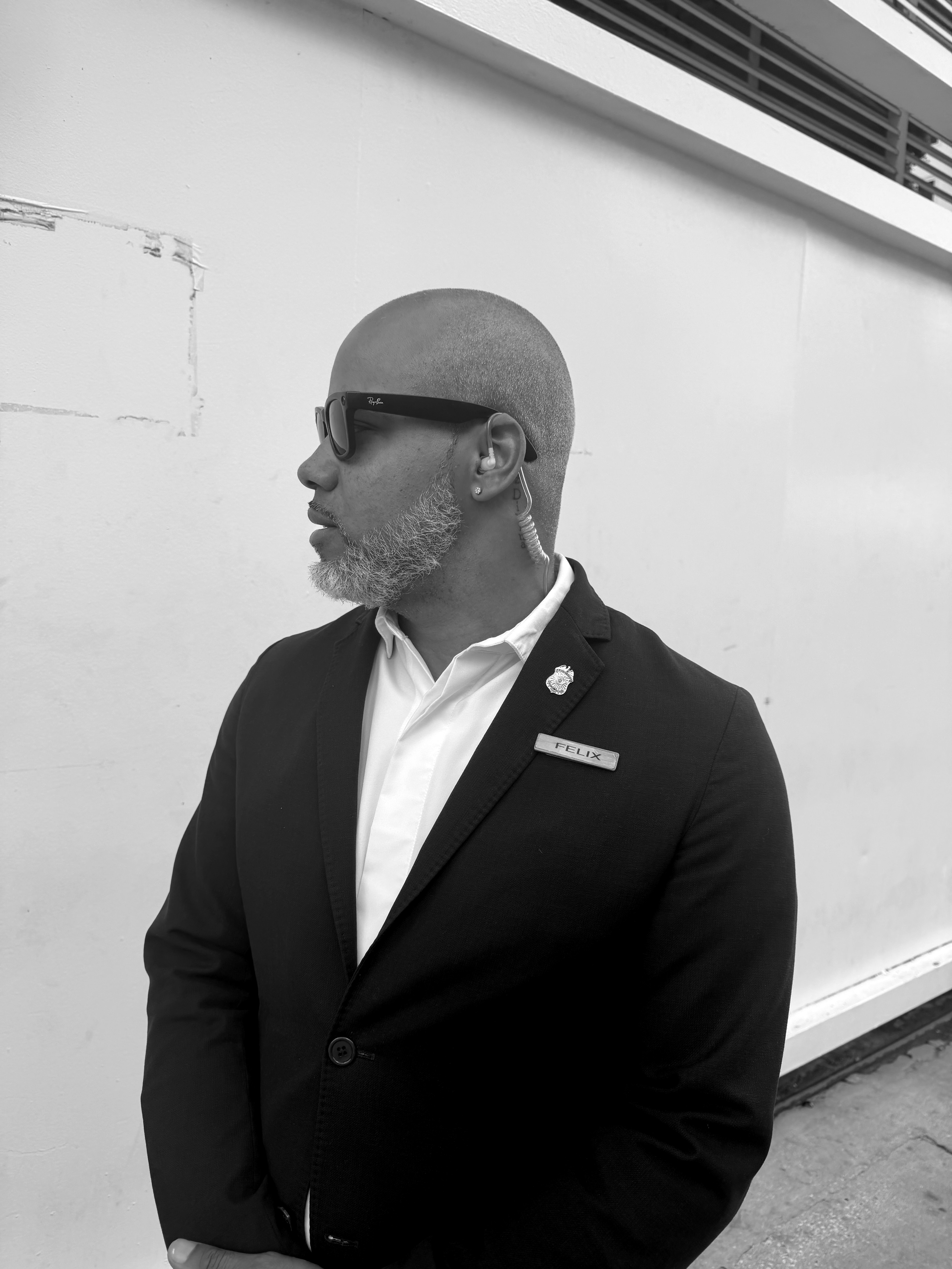 Felix scanning the perimeter with sunglasses and earpiece